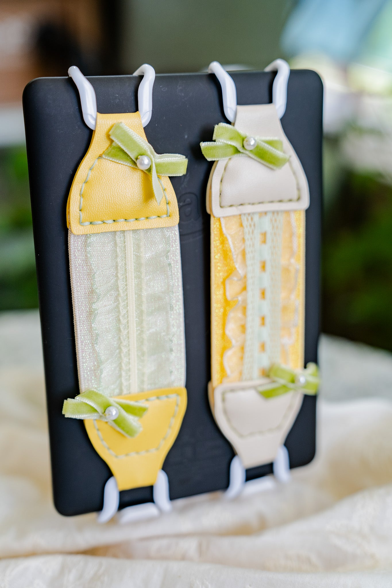 Kittentailor Original Lemon Daylight Kindle grip strap - Handmade with lace, soft vegan leather, green bow, and pearl. Durable metal clips combined for a Coquette aesthetic reading accessory.