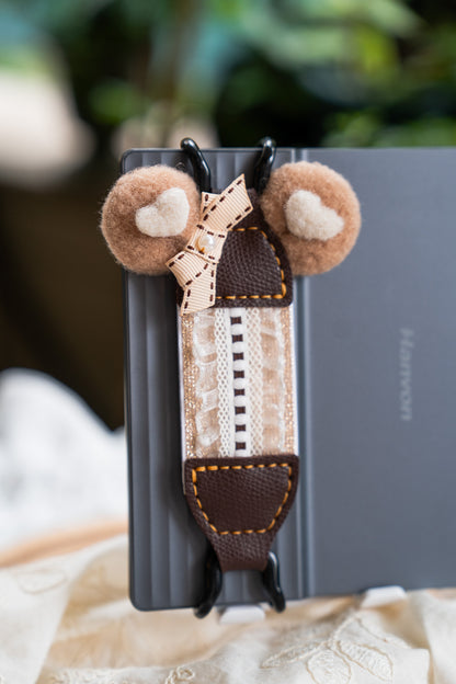 Cookie Thief Bear style with fluffy plush bear ears. Features black metal clips and dark brown vegan leather. Detailed with textured brown stripes, a bow, and pearls. A cozy winter essential and cute gift for teens, fitting Y2K and Y3K aesthetics.