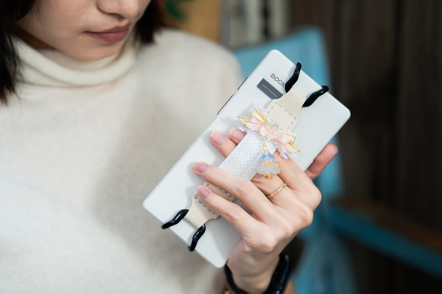 Cozy reading ritual setup with Kittentailor handmade elastic Kindle strap. Best self-care gift idea for book lovers and Kindle girlies. Lightweight e-reader strap for one-handed reading - Perfect for commuting and coffee drinkers.