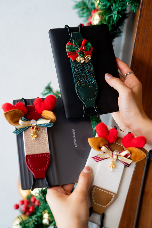 Winter reading strap Make your reading ritual merry and bright! 🎄✨ Our limited-edition Holiday Capsule is here to bring festive cheer to your Kindle.
- The Festive Fawn: Features adorable plush antlers and a jingling gold bell. The champagne glitter elastic adds a touch of magic to every page turn.