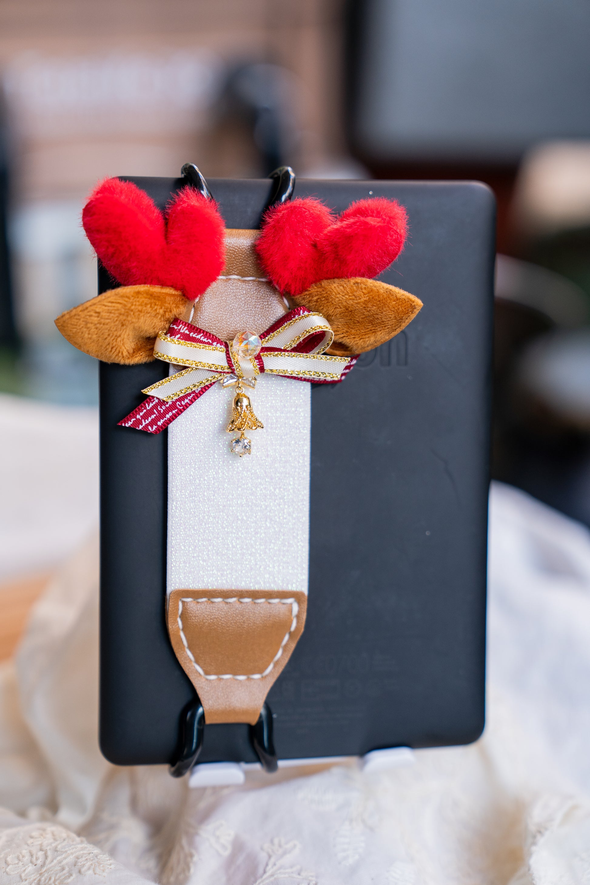 Kittentailor Original Lightweight e-reader strap for one-handed reading - perfect for commuting and coffee drinkers. Cozy reading aesthetic setup with Kittentailor elastic Kindle strap. Essential self-care tool to prevent hand fatigue, soreness, and save your pinky.